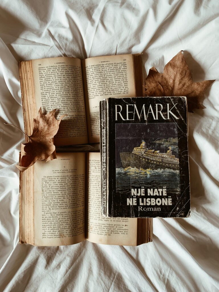 A beautifully arranged flat lay with vintage books and autumn leaves, evoking a classic and cozy atmosphere.